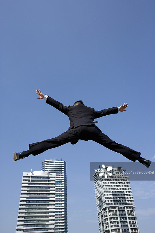 商务人士张开双臂跳跃低角度视图图片素材