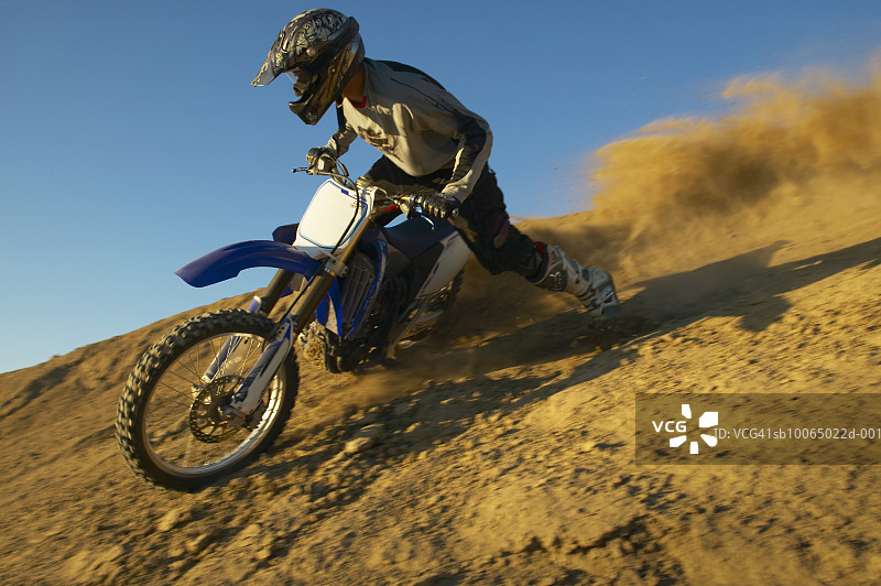 男人在沙漠地形中骑摩托车越野图片素材
