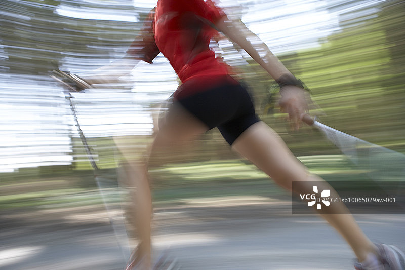 德国巴伐利亚：在森林中进行北欧式健走的女子，低角度拍摄（动态模糊）图片素材