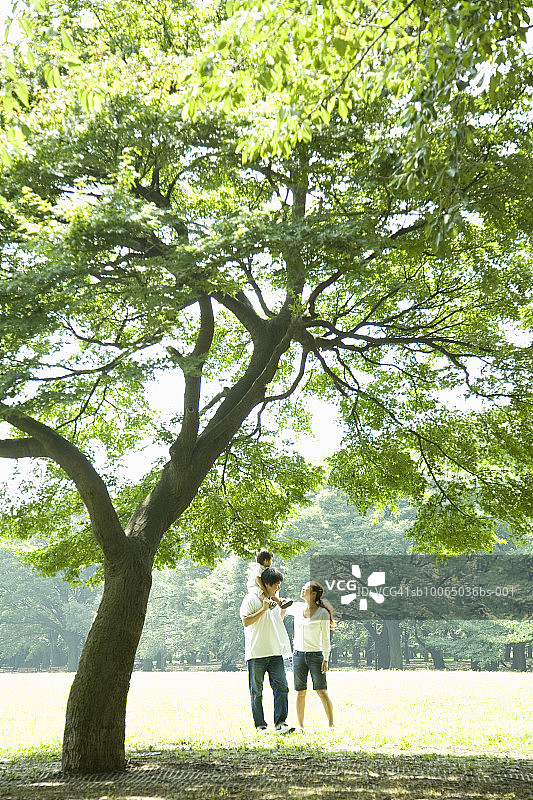 父母和孩子（6-9个月大）在公园里散步图片素材