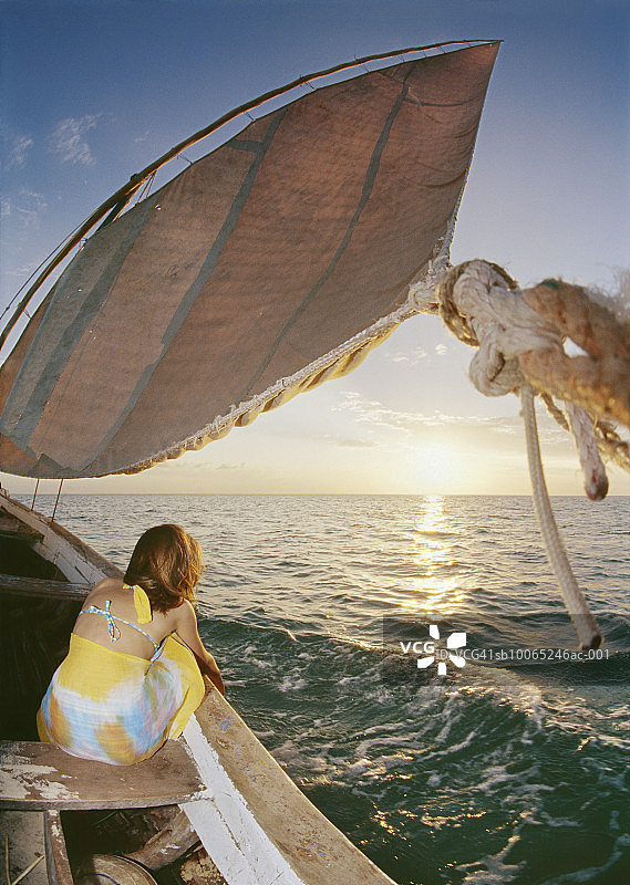 坐在渔船上的少女（13-14岁），后视图图片素材