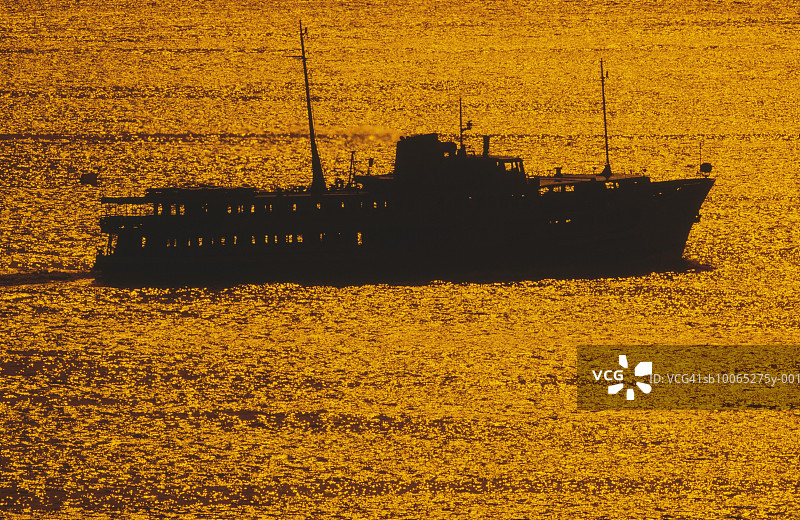 日落时海上的渡轮轮廓图片素材