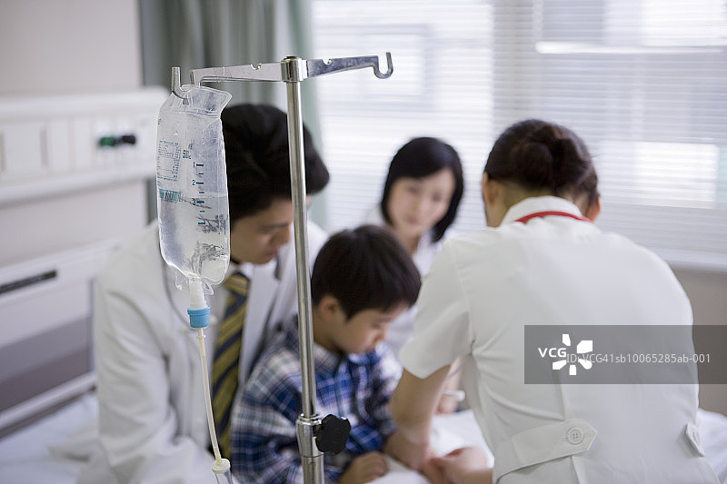 医生和护士在医院病床上照顾男孩(5-6岁)图片素材
