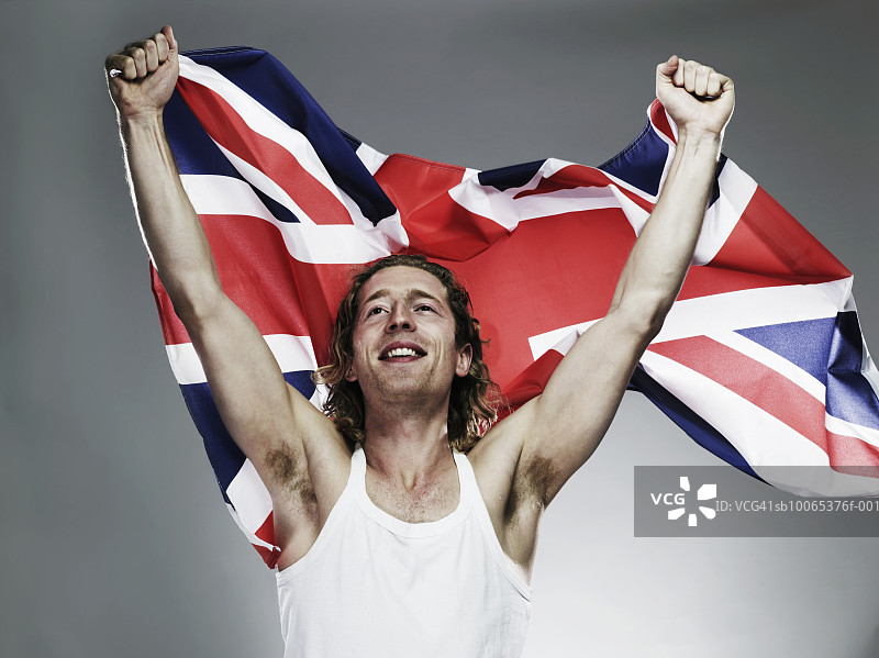 拿着旗帜微笑的年轻男人特写图片素材