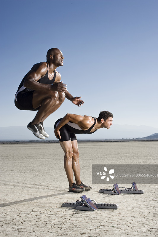 两名运动员在起跑线上热身，侧视图图片素材