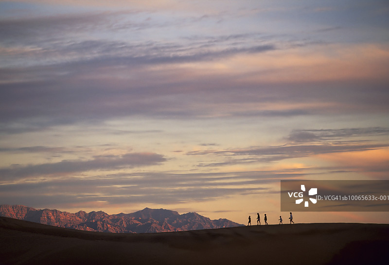 一家人徒步旅行的剪影，日落图片素材