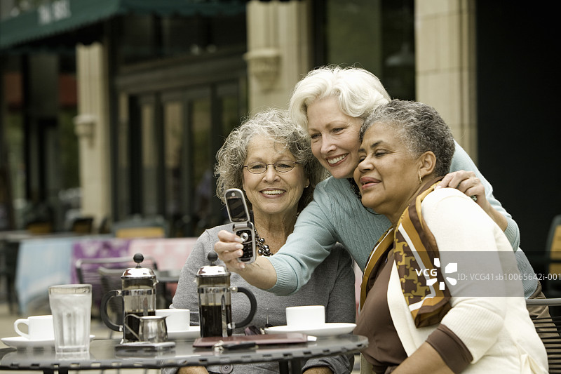 三位老年女性在咖啡馆用手机自拍图片素材
