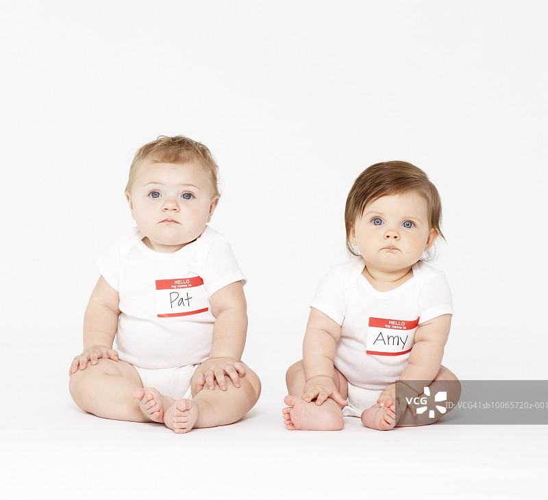 两个坐在白色背景上的婴儿（6-9个月大）图片素材
