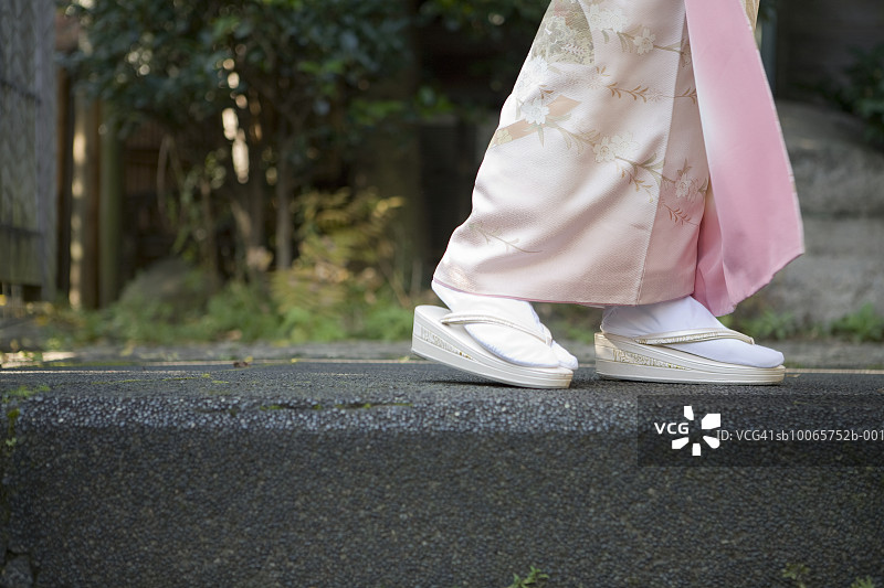 日本东京：身着和服和凉鞋的女子走在水泥路上图片素材