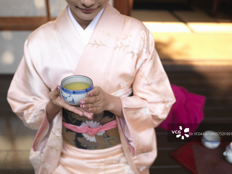 日本东京身穿和服的女子手持绿茶杯图片素材