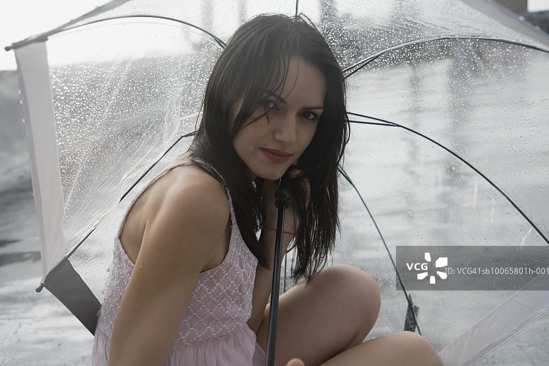 雨中撑伞的年轻女人肖像图片素材