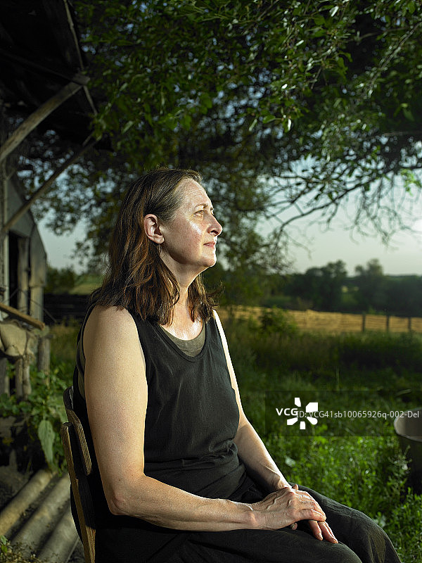 站在农场，侧视的中年妇女图片素材