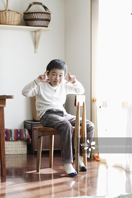 背靠前坐在椅子上的男孩（8-9岁）肖像图片素材