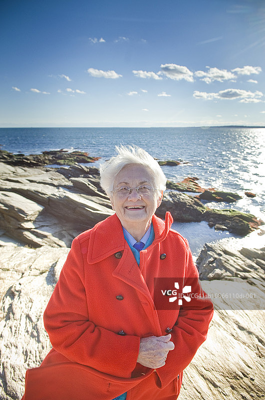 站在海滩上微笑的年长女性肖像图片素材