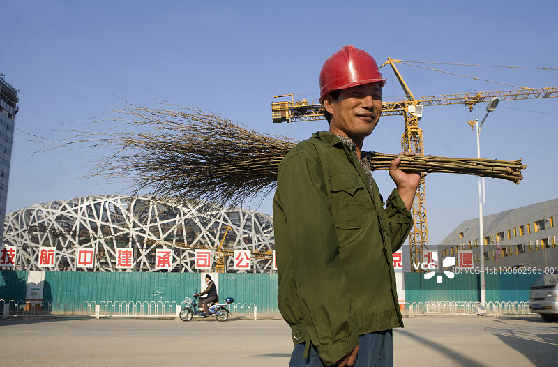 中国北京：手持树枝扫帚的中国工人，面带微笑图片素材