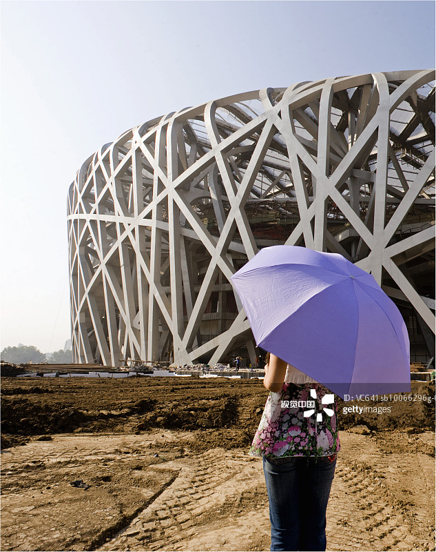 中国北京：女子在建筑工地撑伞图片素材