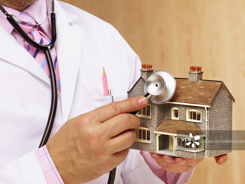 医生用听诊器听诊模型房子的中部图片素材