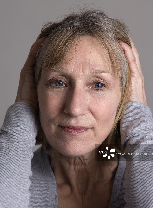 中年妇女双手抱头，特写，工作室拍摄图片素材