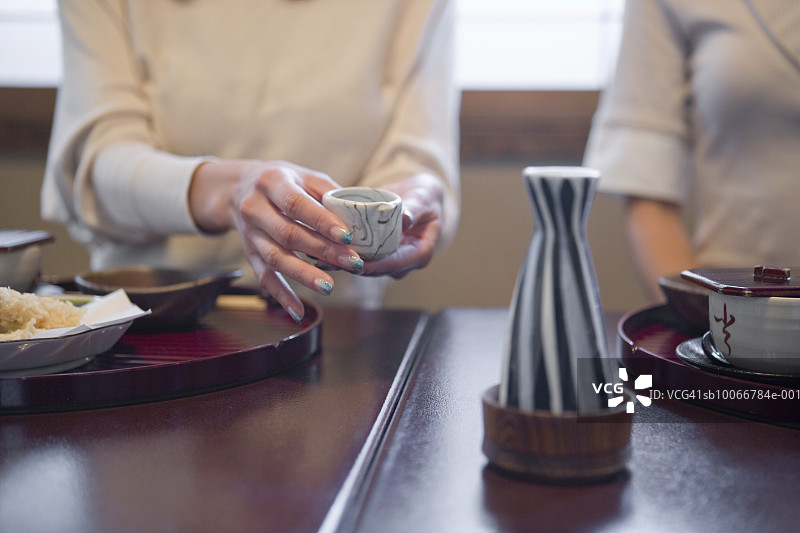 两名女子在传统日式午餐时喝清酒图片素材