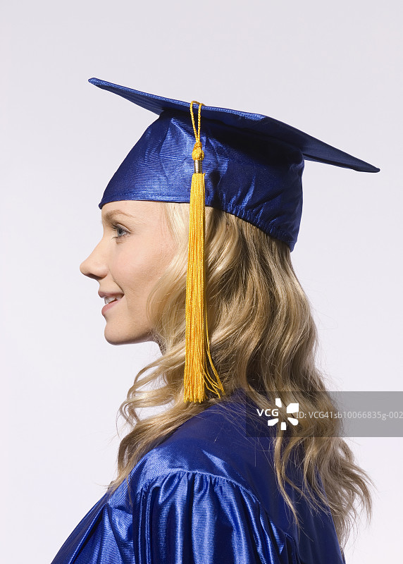 毕业礼服年轻女子侧面照图片素材