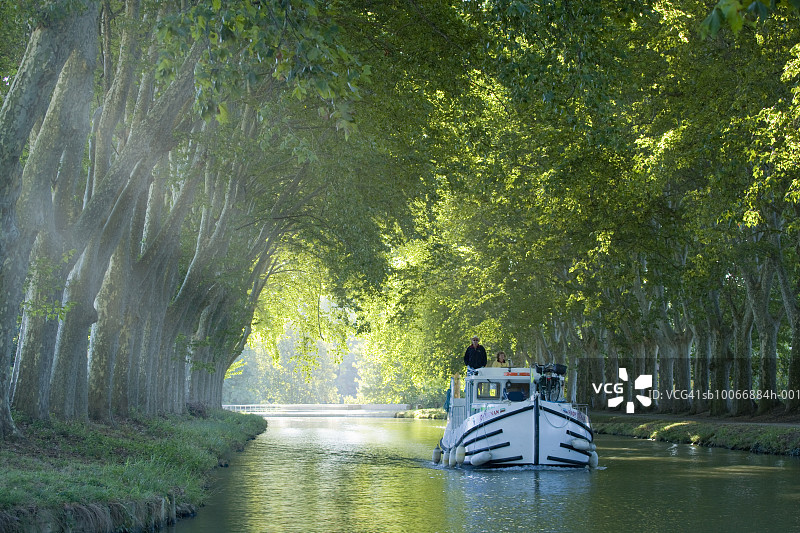 法国朗格多克卡尔卡松，绿树成荫的运河中的船只图片素材