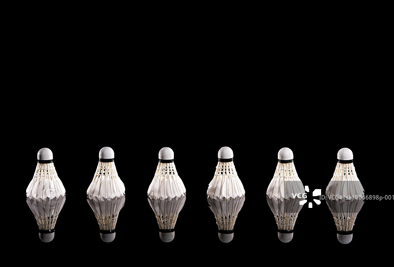 黑色背景上成排的羽毛球图片素材