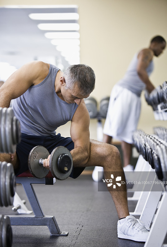 男人在健身房举哑铃图片素材