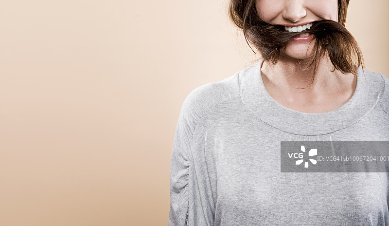 年轻女人嘴里含着头发，中段图片素材