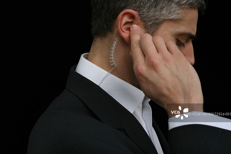 佩戴免提设备的中年商务男士特写图片素材