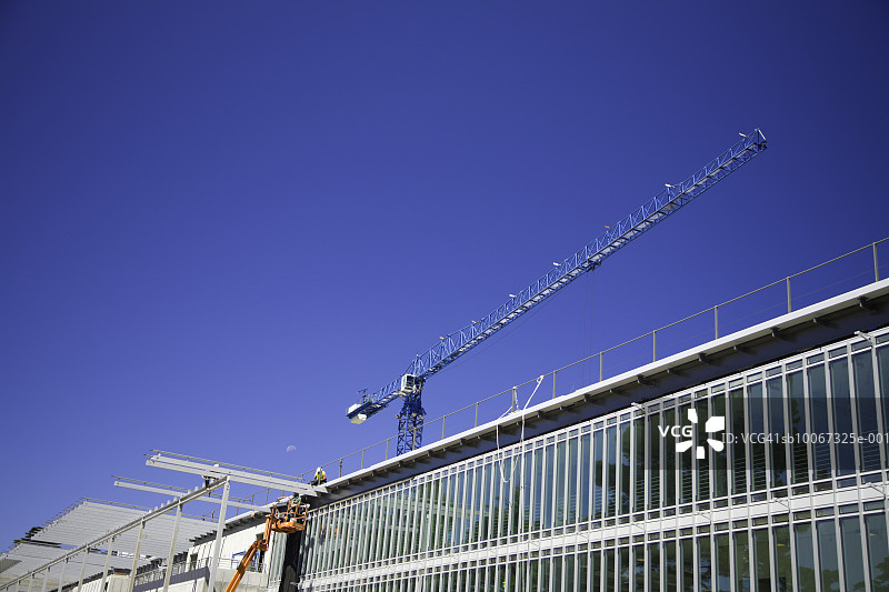 在屋顶上工作的建筑工人，低角度视角图片素材