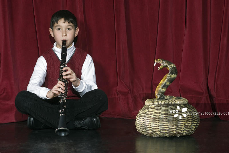 在舞台上用单簧管迷住蛇的男孩（8-9岁）图片素材