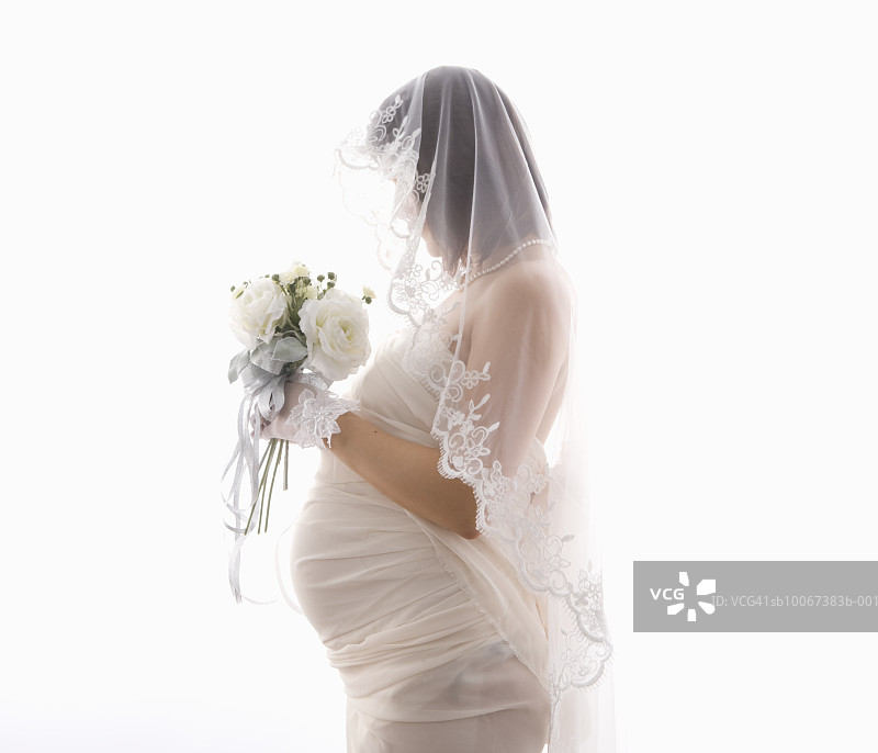 怀孕新娘手捧花，影棚拍摄图片素材