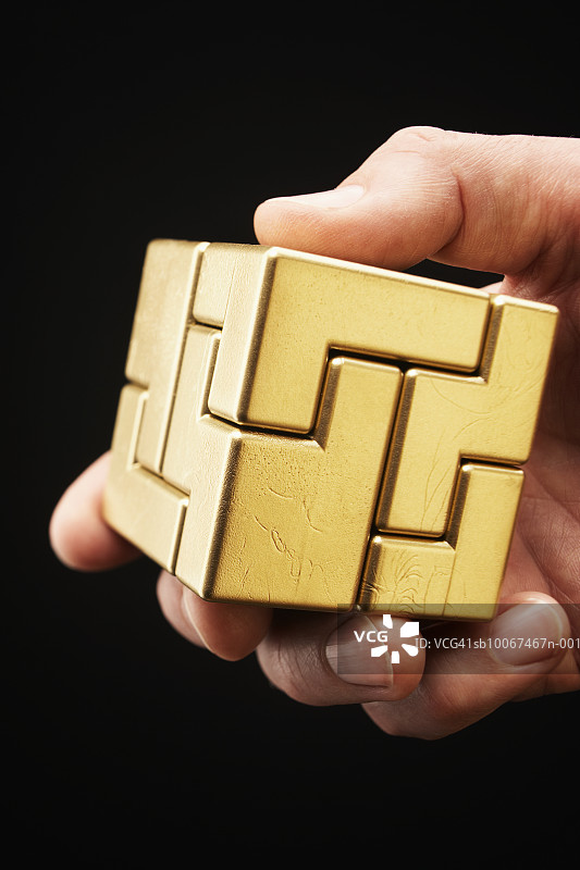 手持金色魔方，特写图片素材