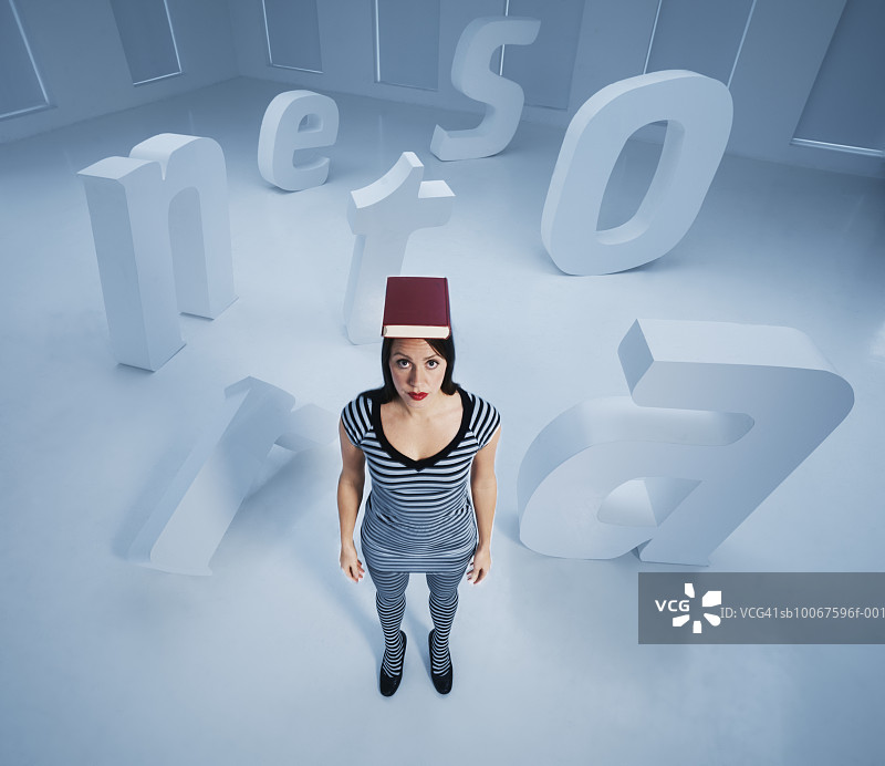 一个女人顶着书站在那里，周围是大大的字母图片素材