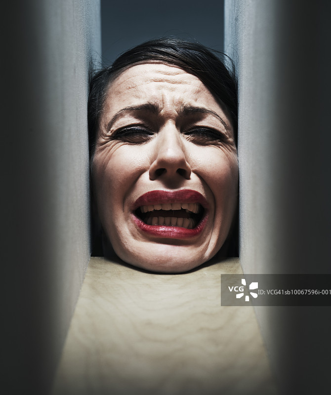 女人的头被困在两堵墙之间图片素材