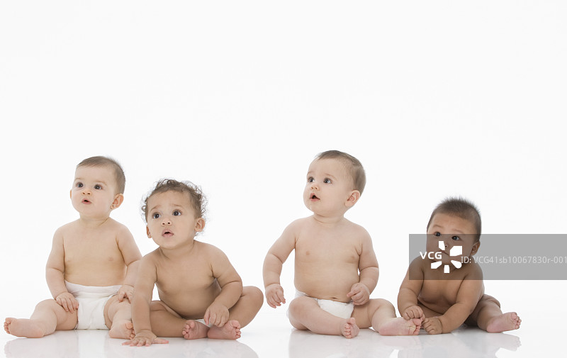 四个男婴（6-11个月）坐在白色背景上图片素材