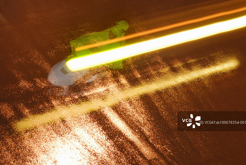 夜间，两人穿雨衣骑摩托车在洪水中图片素材