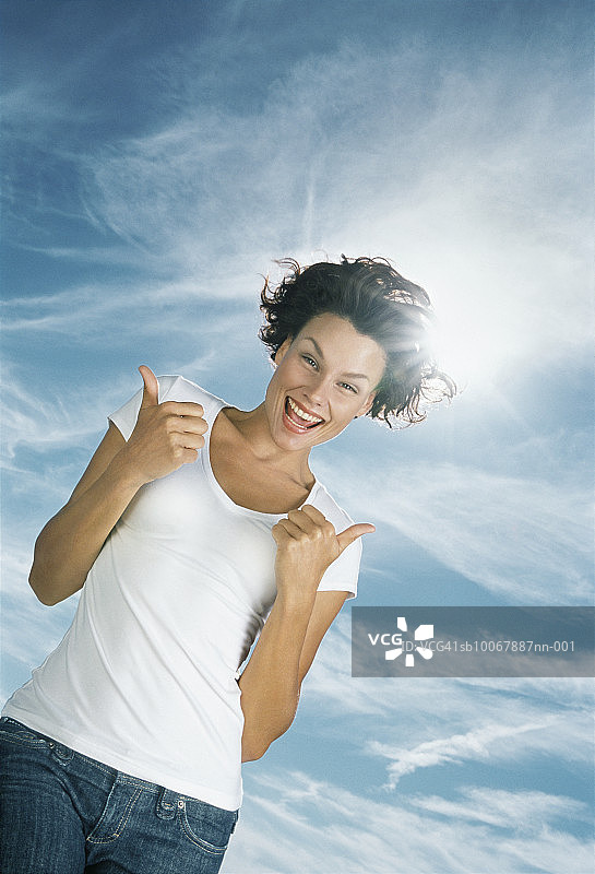 竖起大拇指的女人，低角度肖像图片素材