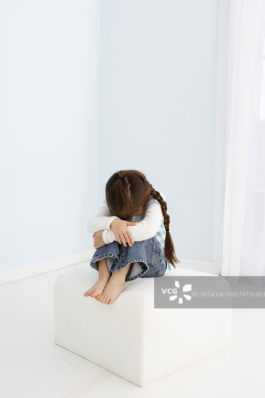 坐在脚凳上的小女孩图片素材