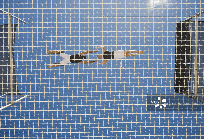 男性高空飞人表演，低角度拍摄图片素材