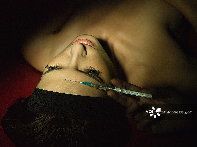 年轻女人接受前额注射图片素材