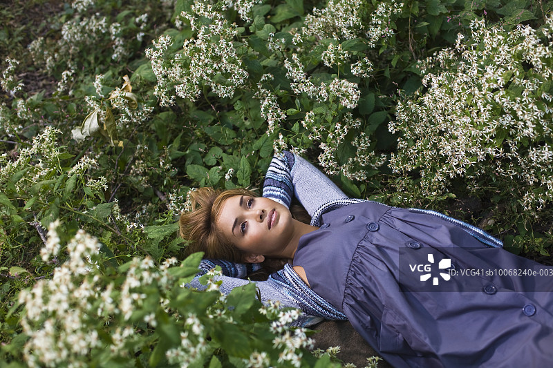 鲜花草地中躺卧的女人，高角度视角图片素材