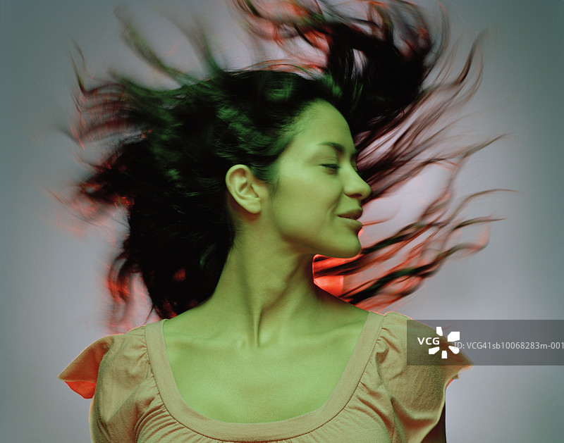 头发在风中飘扬的年轻女人，特写，动态模糊图片素材