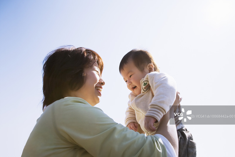 在户外抱着儿子的女人（6-11个月大）图片素材