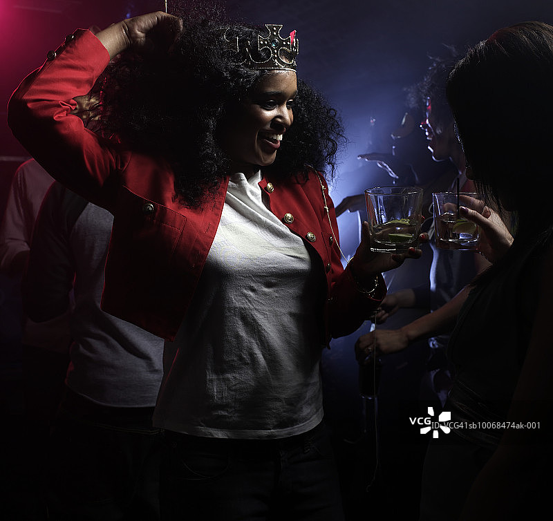 两位年轻女人在夜总会跳舞，一位戴着皇冠图片素材