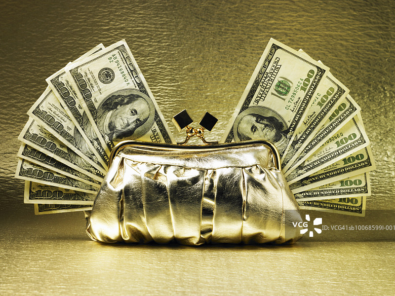金色背景上的扇形百元美钞金钱包图片素材