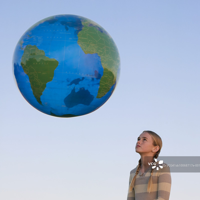女孩看漂浮的大地球仪图片素材