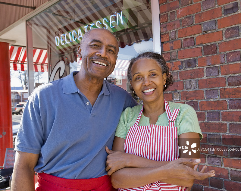 在杂货店前微笑的老年夫妇肖像图片素材