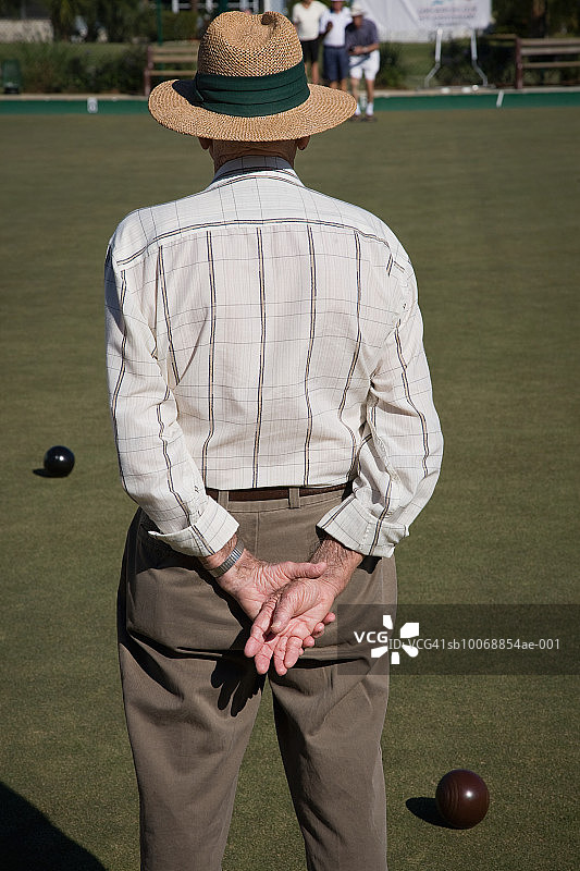 草地滚球比赛中的年长男人，后视图图片素材