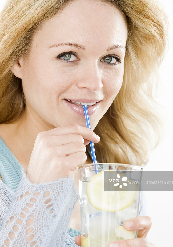 年轻女人喝冰水，微笑特写肖像图片素材